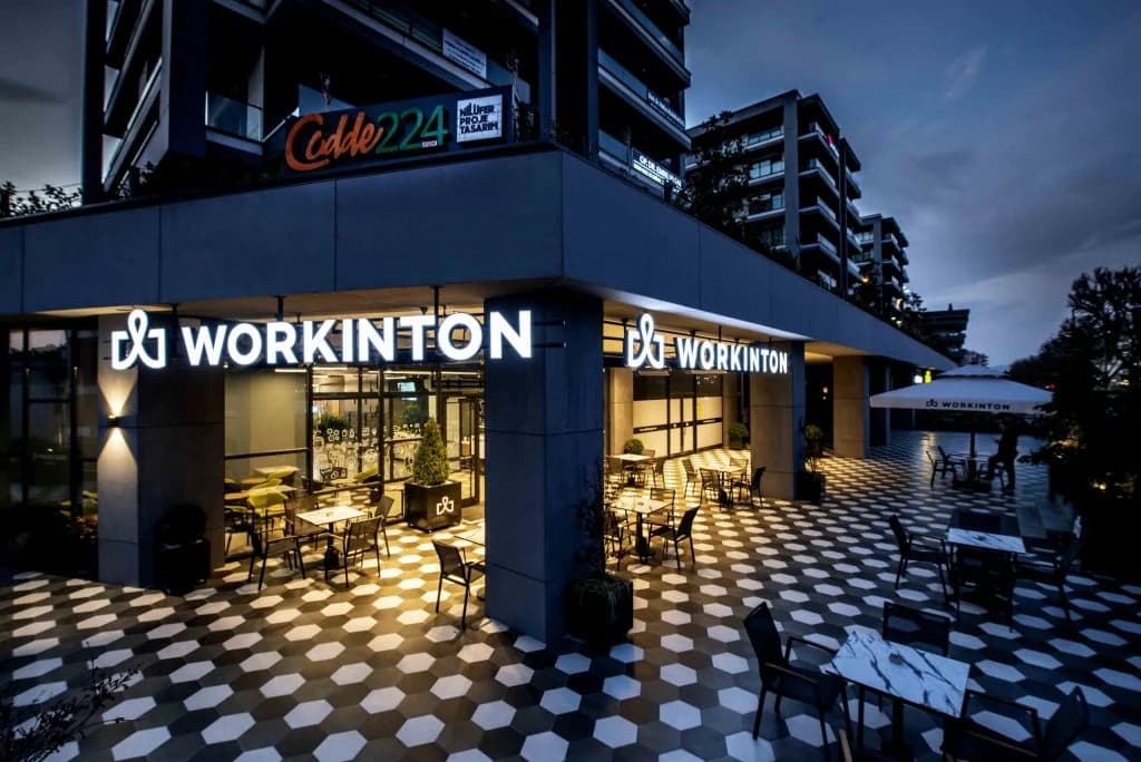 Akşam ışıklarında Workinton binasının dış cephesi ve giriş alanı